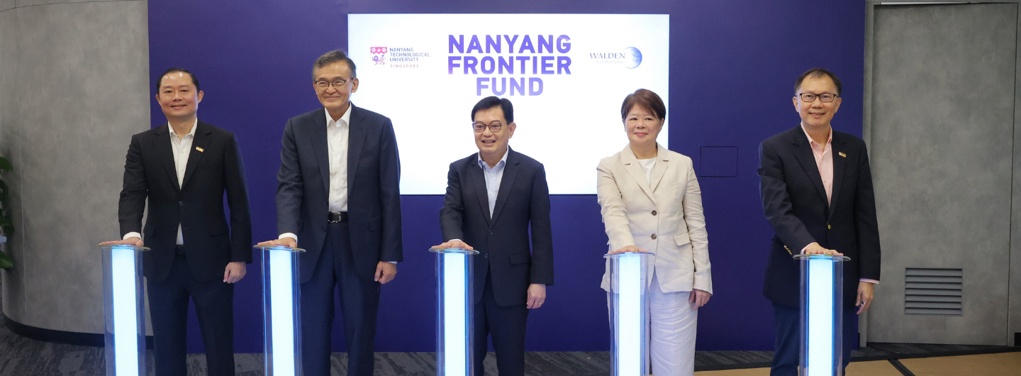 Five people in business attire stand behind illuminated podiums; "Nanyang Frontier Fund" backdrop.